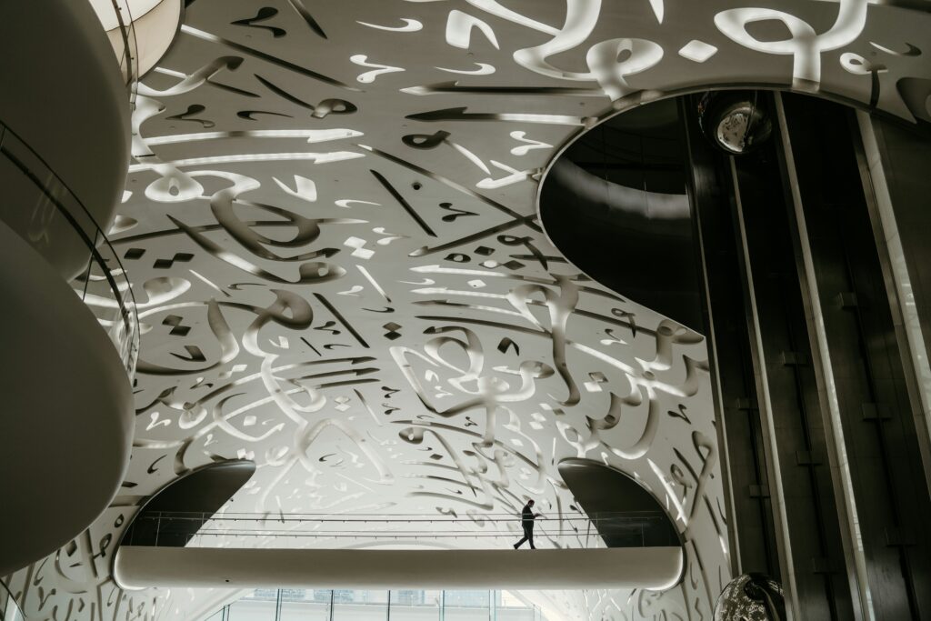 Interior of Museum of the Future Dubai featuring white spiral staircase and Arabic calligraphy walls.