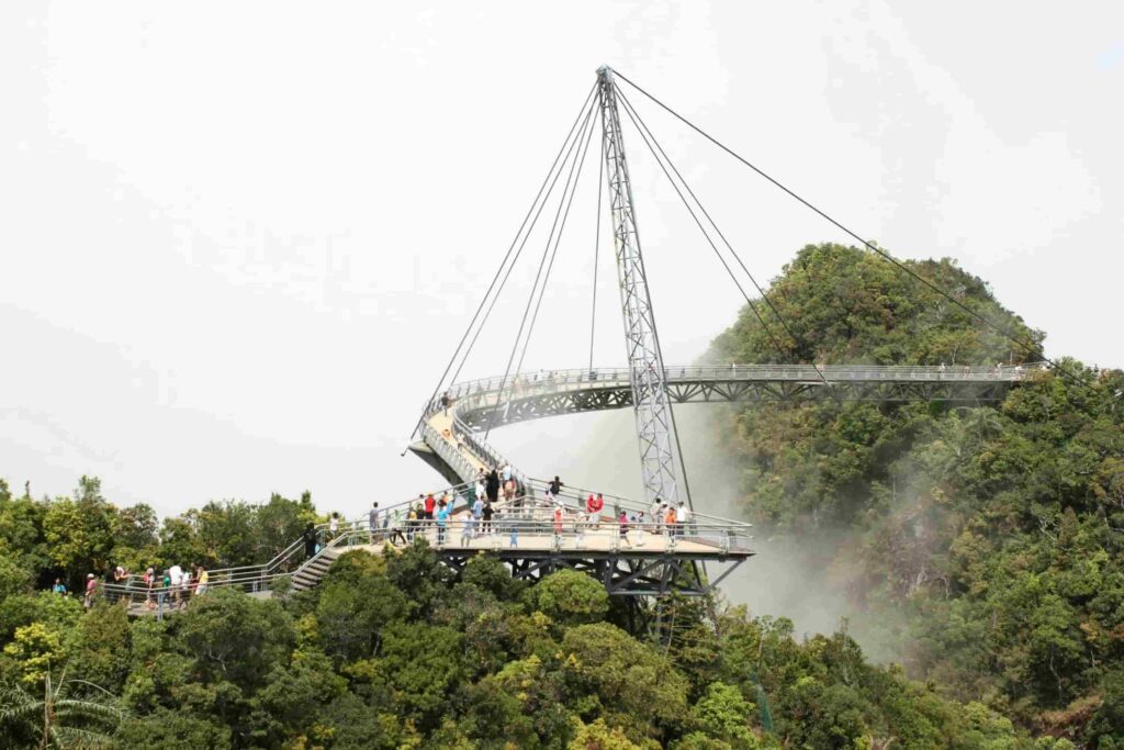 Visitors walking on Langkawi Sky Bridge suspended in mist above rainforest on Gunung Mat Cincang Malaysia, Langkawi Sky Bridge