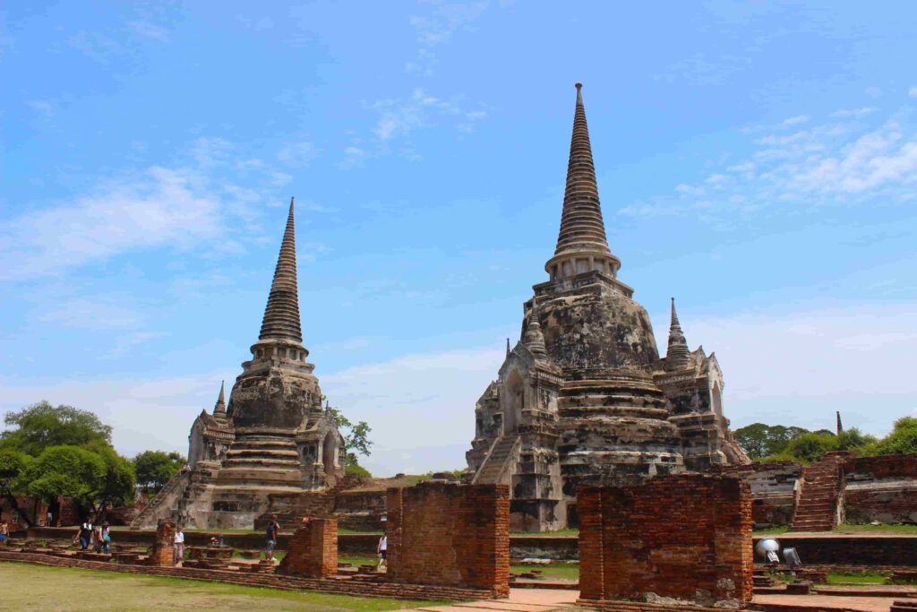 Two historic stone chedis and ancient brick walls at Wat Phra Si Sanphet in Ayutthaya historical park