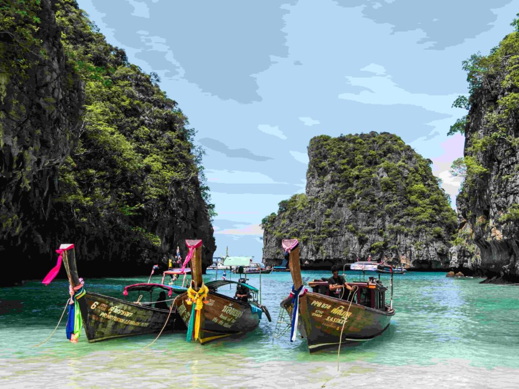 Traditional Thai long-tail boats floating on crystal-clear water at Phi Phi Islands in Thailand