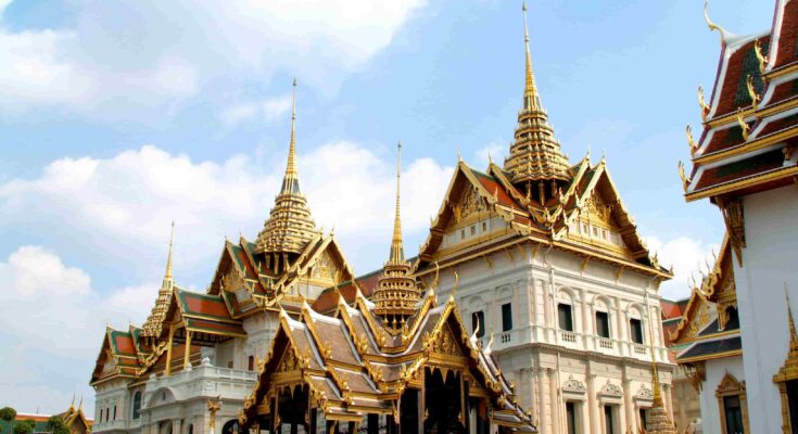 Chakri Maha Prasat European architecture and golden spired roofs at the Grand Palace Bangkok.