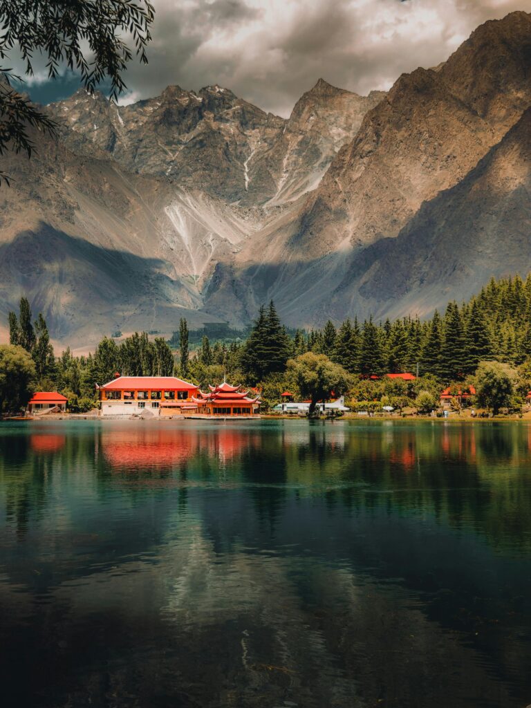 Beautiful Shangrila Resort and Lower Kachura Lake with red-roofed cottages reflecting in the water.
