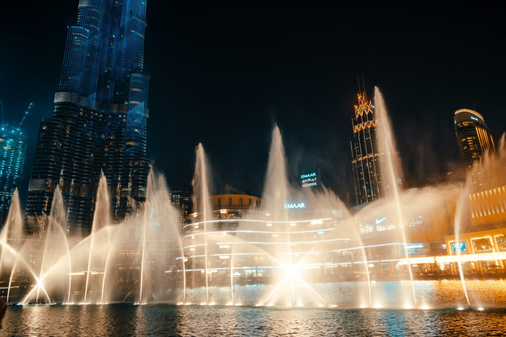 The Dubai Fountain show with Burj Khalifa illuminated at night in Downtown Dubai