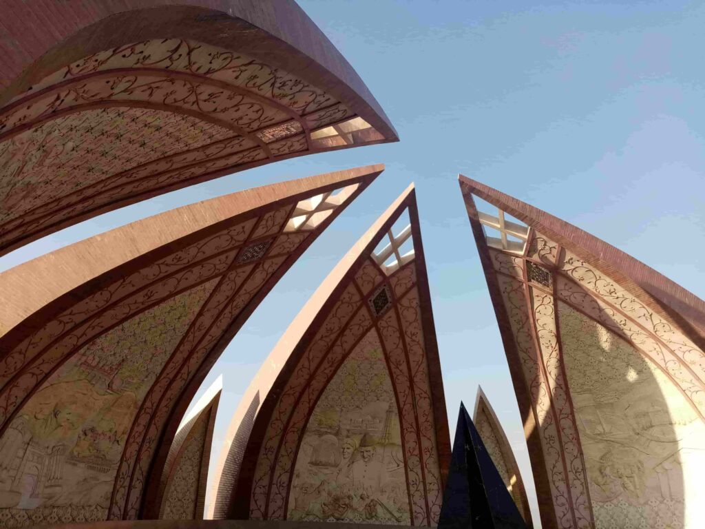 Low-angle shot of the blooming granite petals and detailed historical murals at the Pakistan Monument in Islamabad.