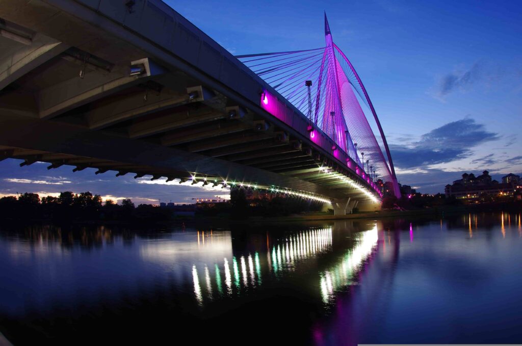 Seri Wawasan Bridge lit up in purple over Putrajaya Lake at dusk